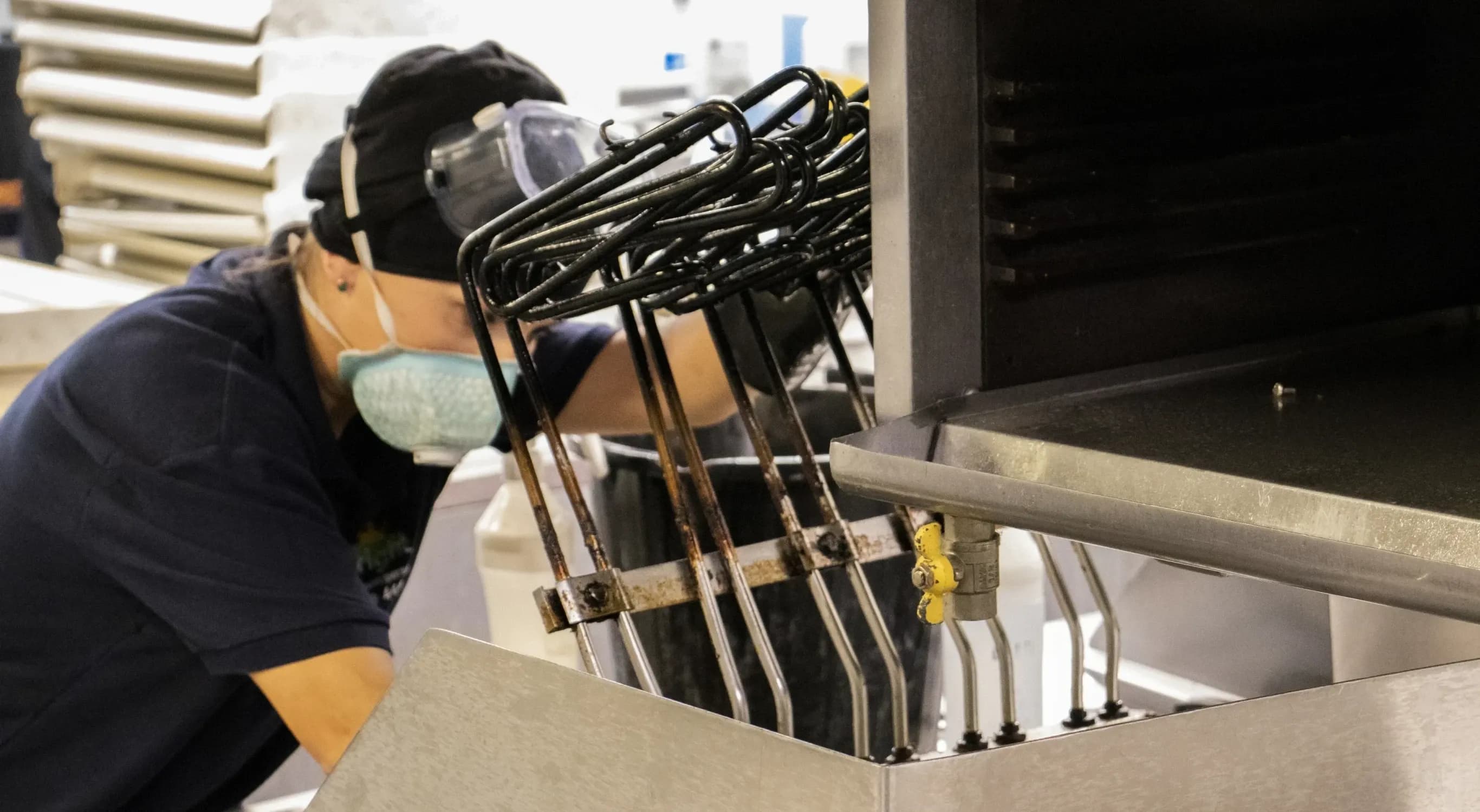 Bright technician performing bespoke deep cleaning in a commercial kitchen.