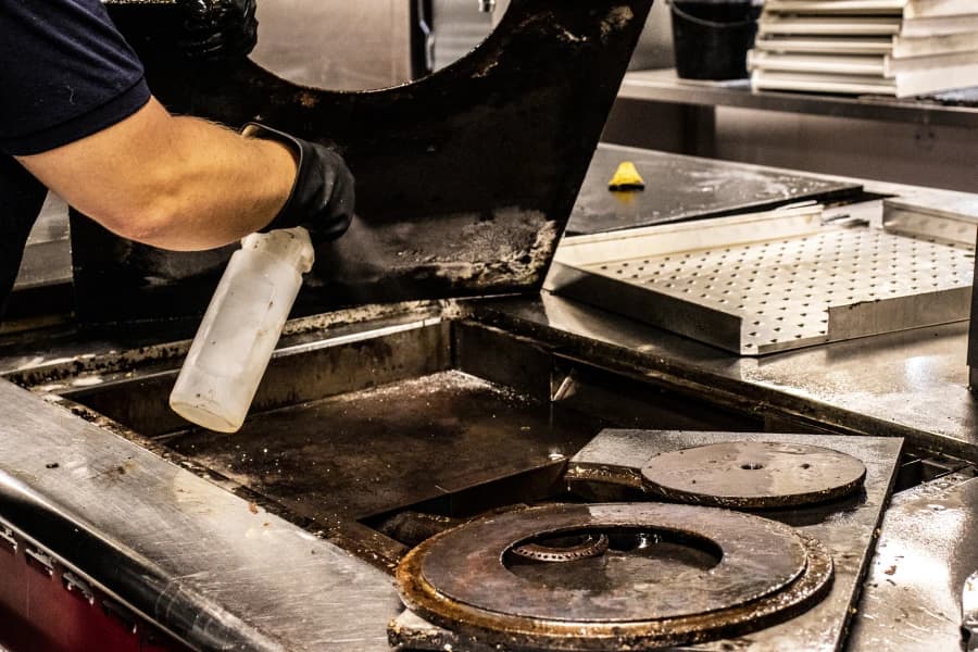 Bright technician spraying and disinfecting surfaces as part of specialist cleaning for secure facilities.