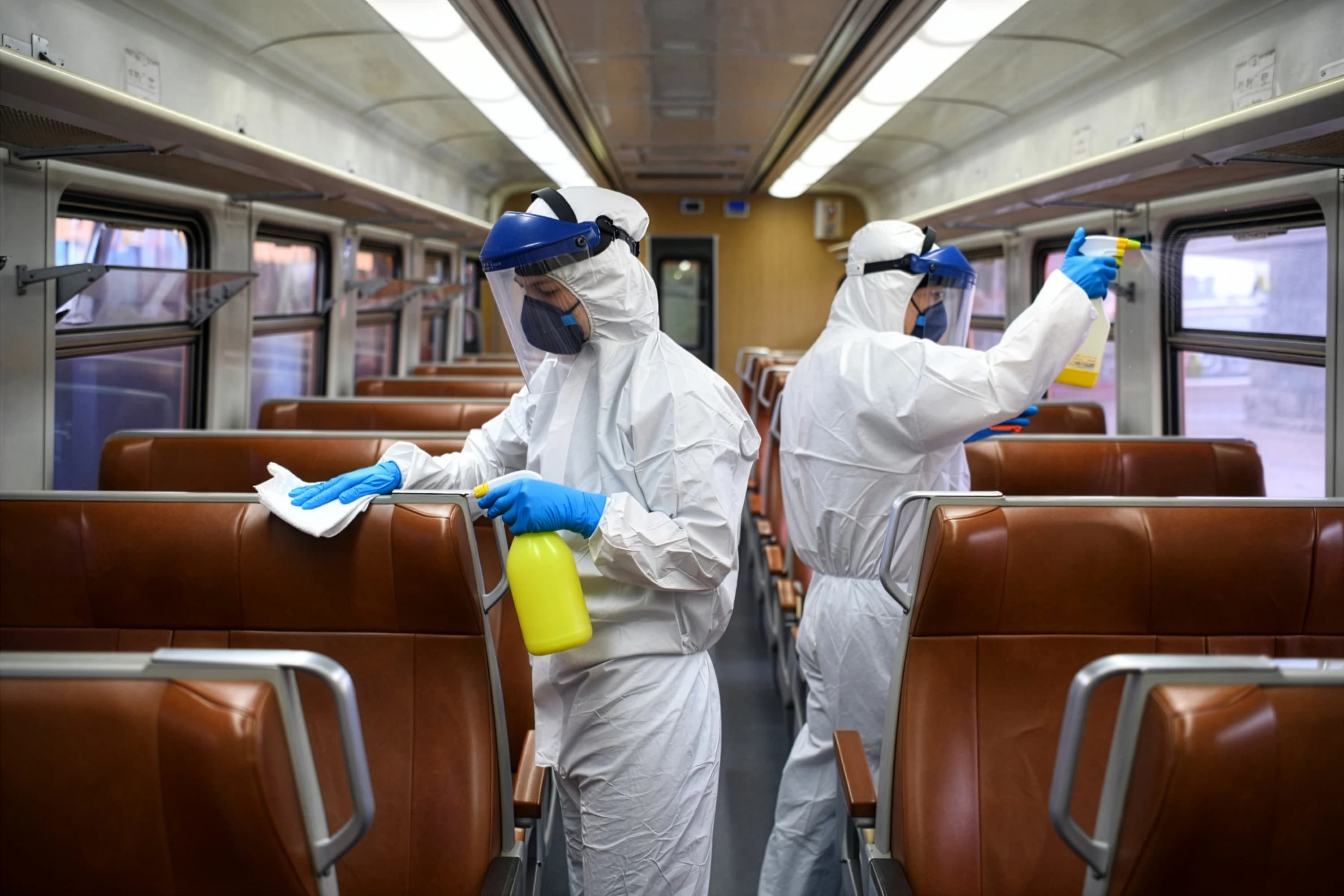 Technician sanitising public transport environment using specialist cleaning equipment.
